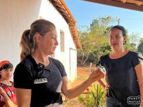 Dalila Vasconcelos (left) holds up a refractometer for measuring sweetness (in "brix"). 