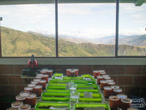 Pouring a table of coffees at the cupping lab above the green coffee storage warehouse in Buesaco town