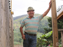 Hector Bonilla of the Don Mayo micromill poses for a photo at the top of the stairway that leads to the drying patios. Don Mayo mill, Tarrazu, Costa Rica.