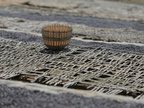 Woven basket used for sorting coffee rests on woven bamboo drying beds at a processing site in Uraga area.