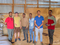 Tom poses for a photo with some of the team working at the Buliye coffee mill.