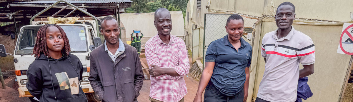 Five people who are part of the operations team at Gibuzale mill stand in line with mill manager Ramona, located far left.