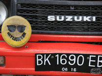 Colorful red Suzuki along the road in Java Sunda.