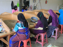Women sort out the worst physical defects by hand at an Aceh mill.