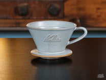The Kalita MINO Ceramic Dripper comes in a cool, bluish "Sand Gray" colorway.
